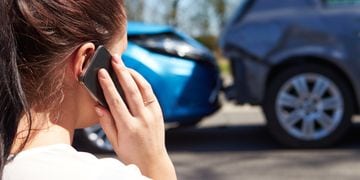 woman looking at an accident while talking in a phone