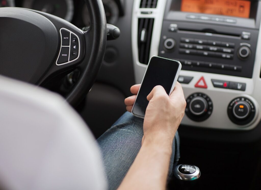 A picture of a person texting while driving