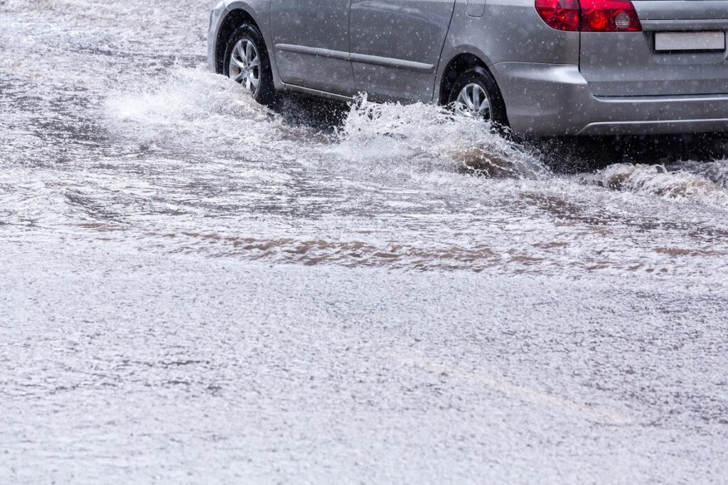 Car driving through flash flooding on road