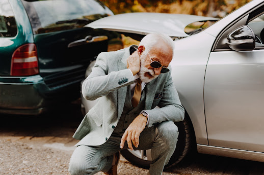 man clutching his neck at the site of an accident